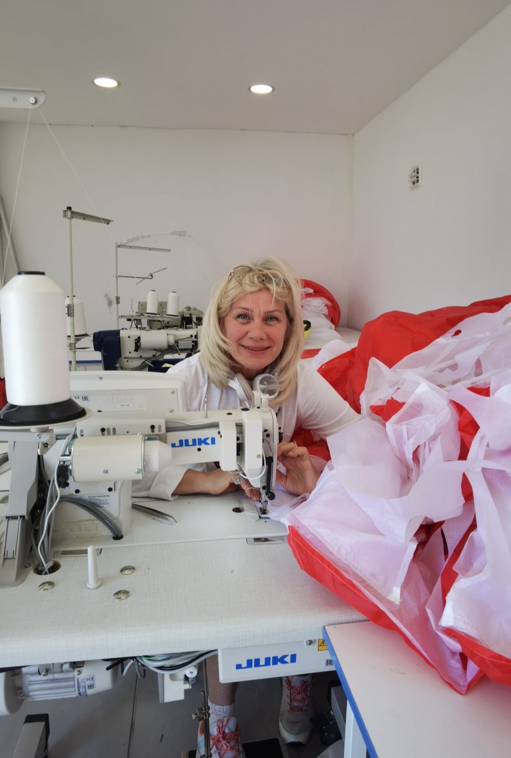 Sewing red and white paraglider.